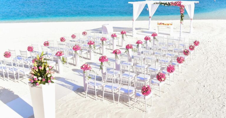 Beach wedding with pink floral arrangements