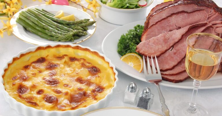 A beautifully arranged Easter feast featuring glazed ham and creamy scalloped potatoes.