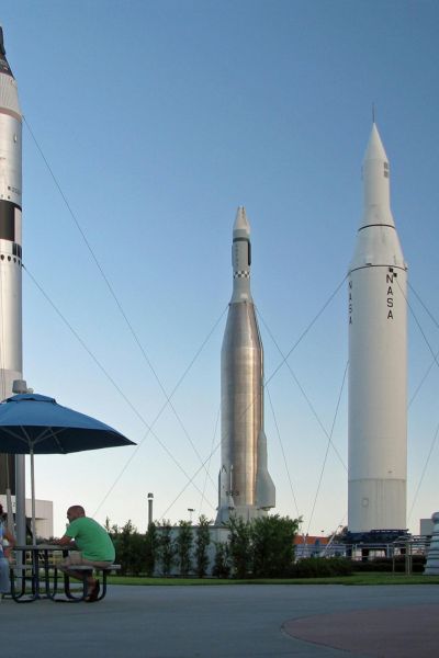 A peaceful scene with a blue umbrella providing shade, surrounded by monumental rockets.