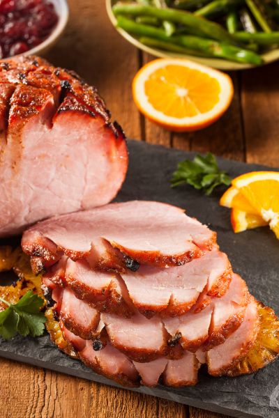 A beautifully glazed ham on a slate platter, ready to serve.