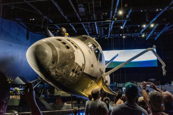 Families gather to admire the retired shuttle, sparking curiosity about space travel.