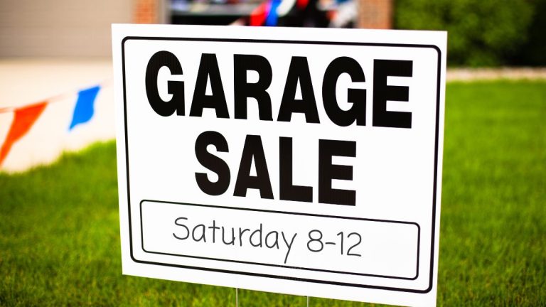 Garage sale sign in a front yard