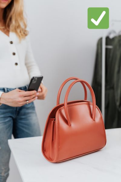 Woman taking a photo of a purse for sale to make fast cash