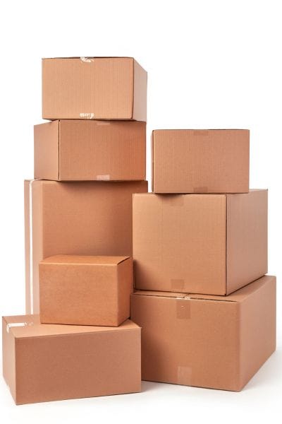 Stack of cardboard shipping boxes for packing Whatnot orders, showing useful whatnot seller supplies for live sellers.